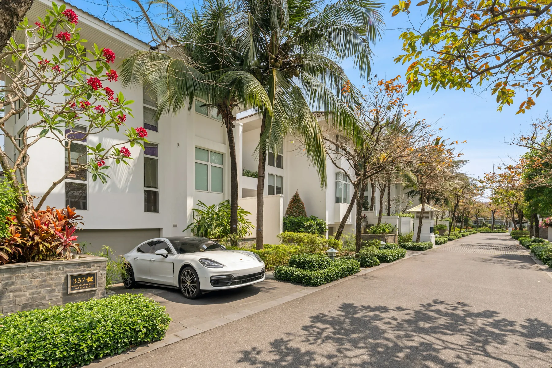 Luxury car beside contemporary tropical architecture; illustrative lifestyle photography
